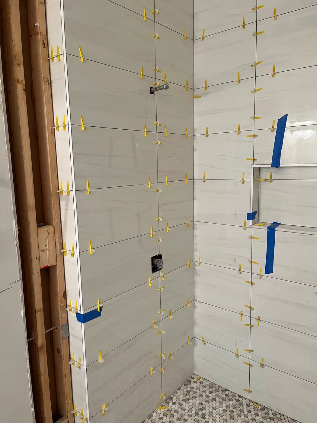 Shower wall tile installation in progress, spacers holding the joints in place, master bathroom remodel, Metro Atlanta