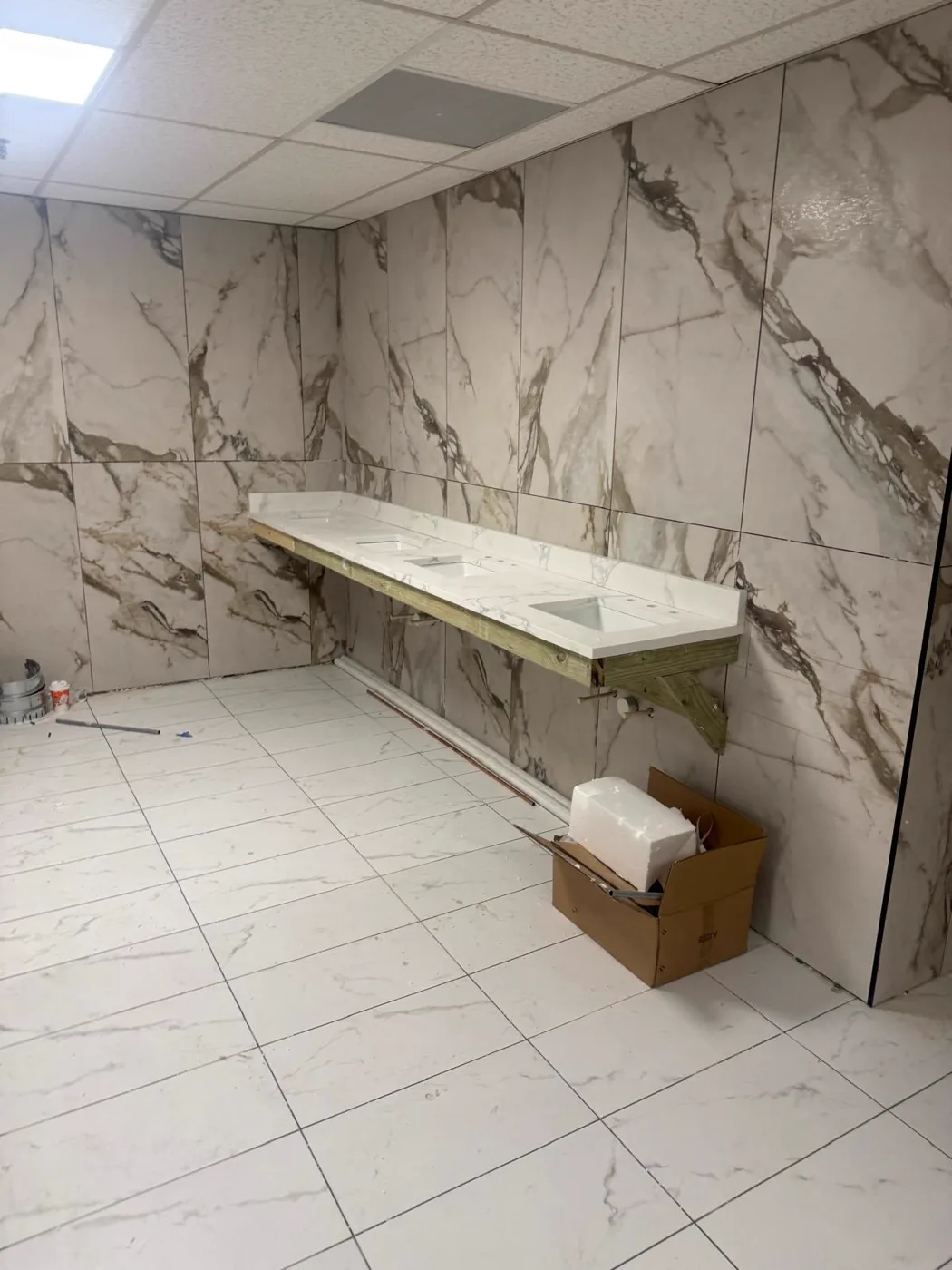 Long marble vanity wall in a finished commercial restroom, venue renovation, Metro Atlanta