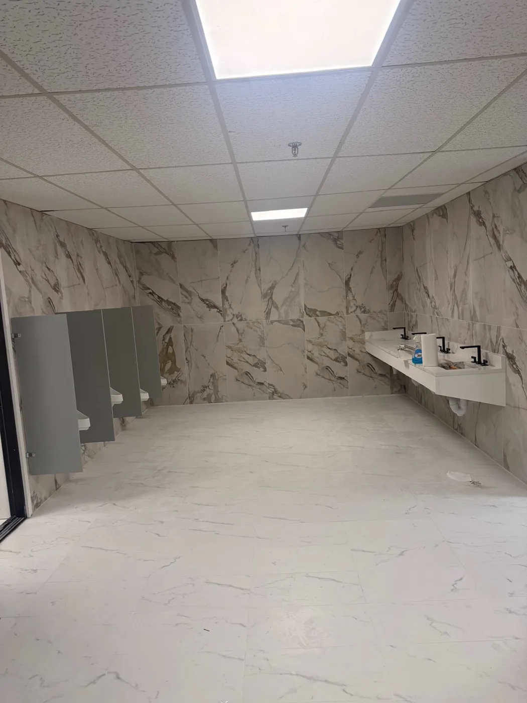 Finished commercial restroom with marble walls and marble-topped sinks, venue renovation, Metro Atlanta