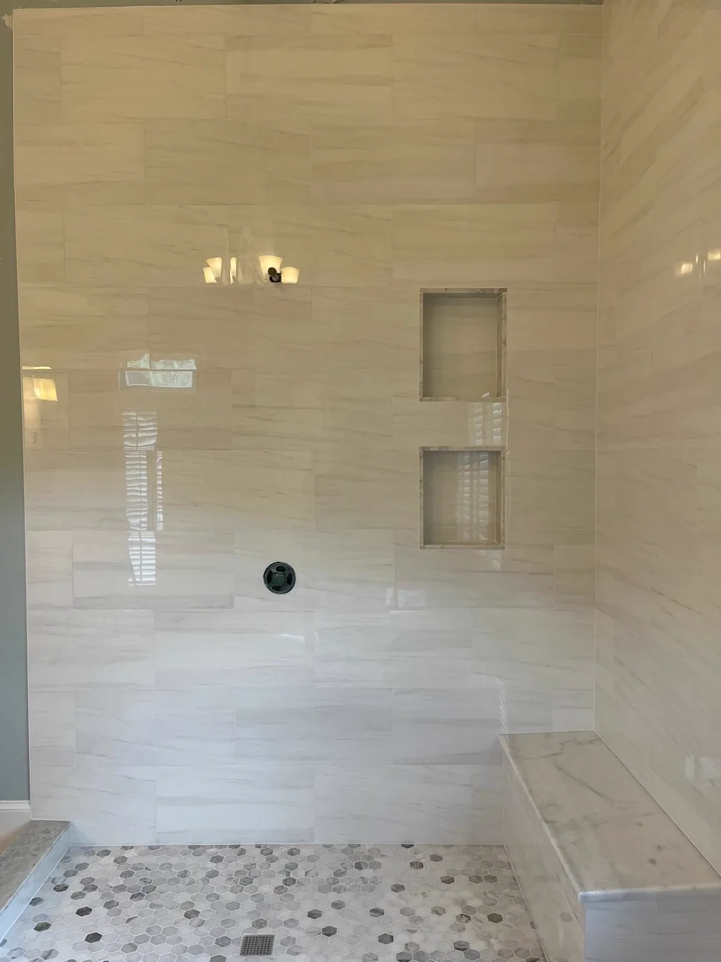 Finished spa shower with marble walls and a pebble tile floor, commercial venue renovation, Metro Atlanta