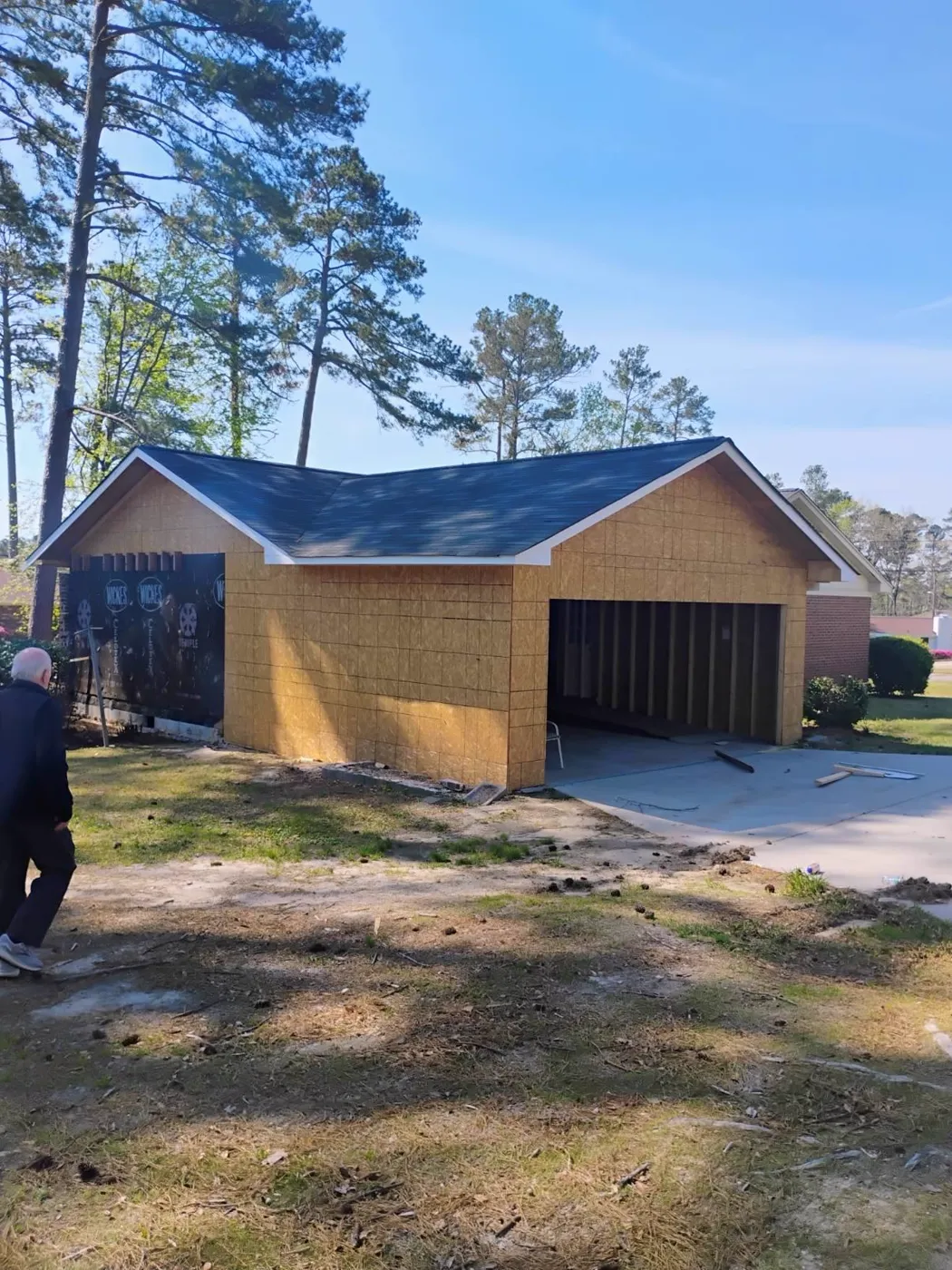 Detached garage under construction with new sheathing, roof and a poured concrete apron, Metro Atlanta